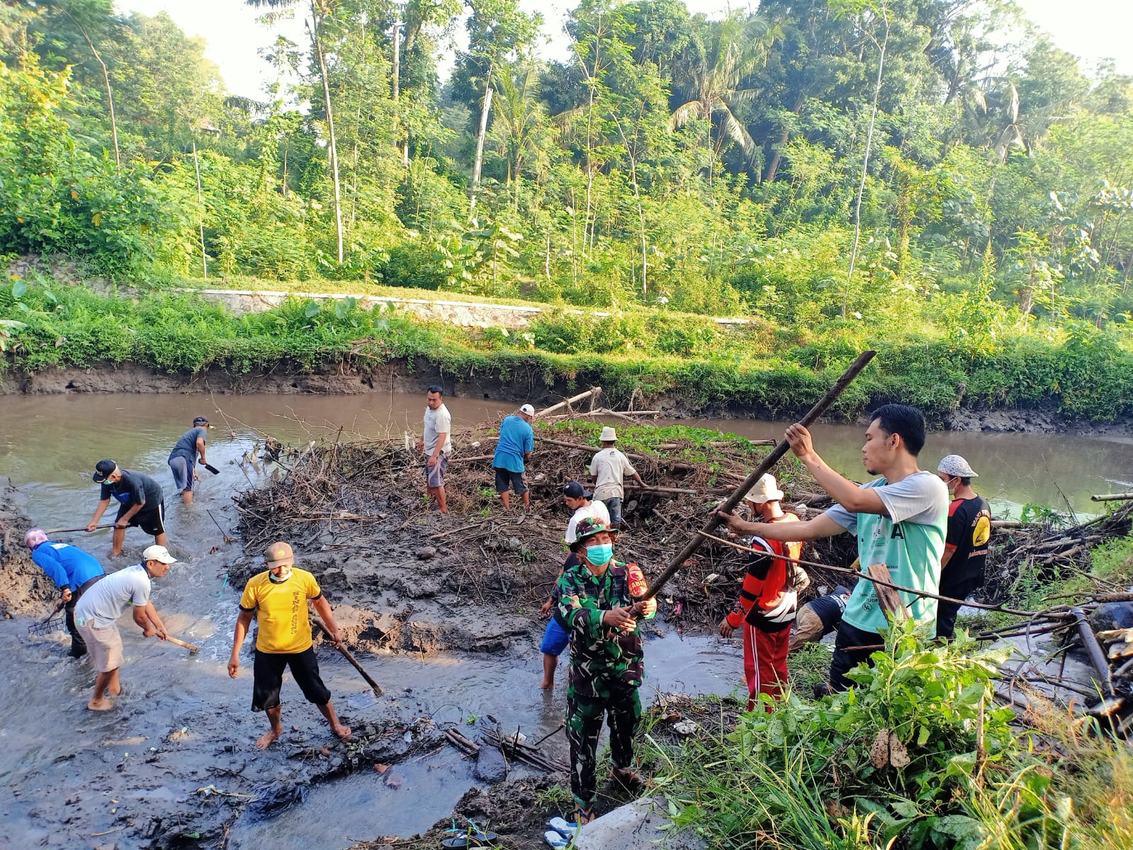 Peduli Kebersihan Sungai, Babinsa Koramil Tipe B 0808/01 Sukorejo Dan Warga Gelar Kerja Bakti Bersama, Minggu (27/02/2022), (V24/Madli)