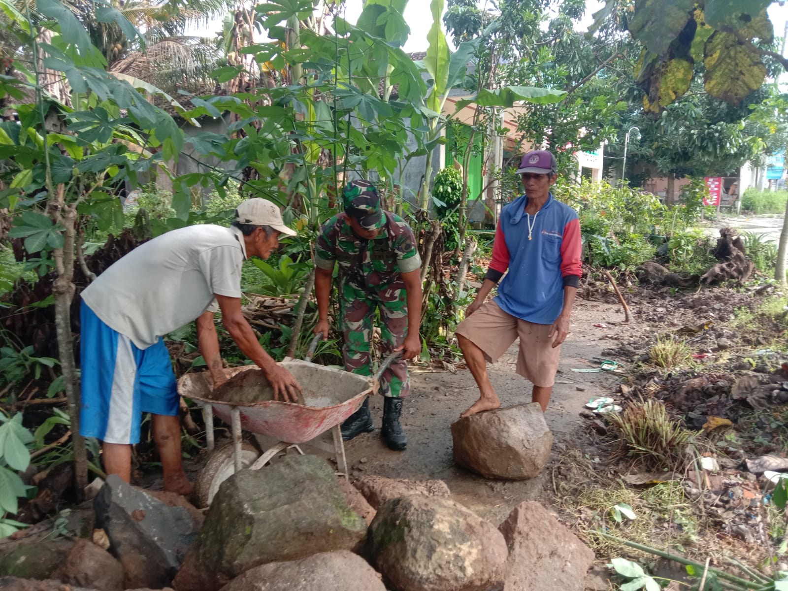 Babinsa Membantu Warga Mengangkat Batu Besar, Jumat (08/04/2022), (V24/Rudi)