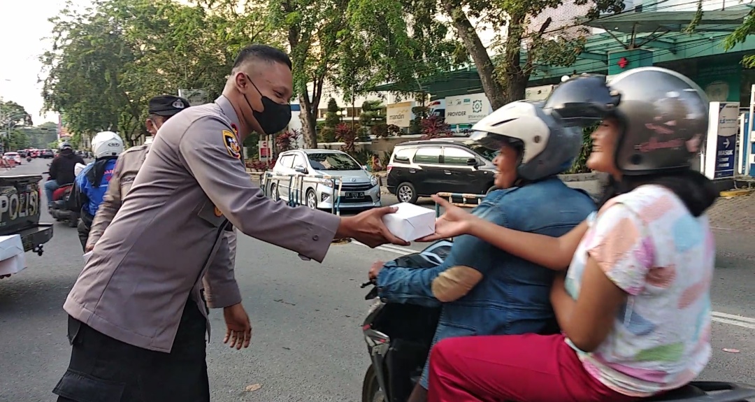 Polsek Medan Timur Membagikan Makanan Kepada Pengendara yang Melintas, Jumat (22/04/2022), (Foto: V24/M.anwar)