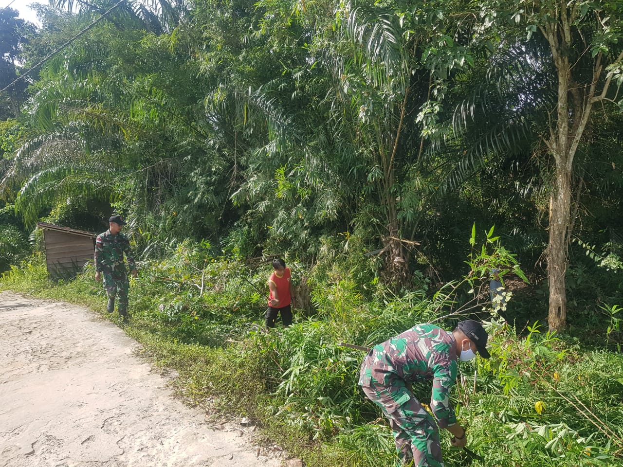 Warga Dan Satgas di Desa Riam Sejawak Kecamatan Ketungau Hulu Bersih-bersih Jalan, Sabtu (23/04/2022), (Foto: V24/AL)